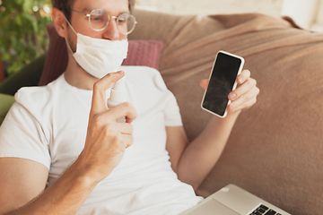 Image showing Young man studying at home during online courses for disinfector, nurse, medical services