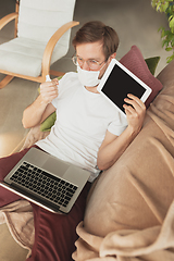 Image showing Young man studying at home during online courses for disinfector, nurse, medical services