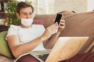 Image showing Young man studying at home during online courses for disinfector, nurse, medical services