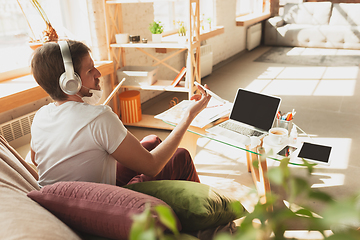 Image showing Young man studying at home during online courses for musician, drummer, producer