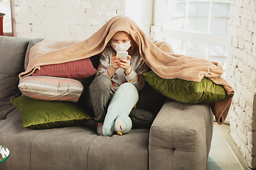 Image showing Little girl in protective mask isolated at home with coronavirus symptoms, stop epidemic