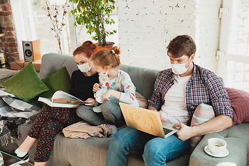 Image showing Caucasian family in protective masks and gloves isolated at home with coronavirus symptoms, treatment