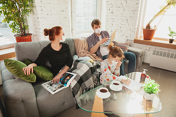 Image showing Caucasian family in protective masks and gloves isolated at home with coronavirus symptoms, treatment