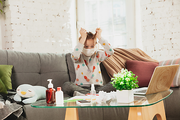 Image showing Little girl in protective mask isolated at home with coronavirus symptoms, stop epidemic