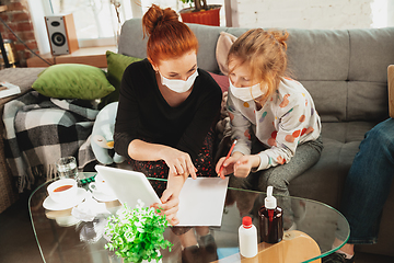 Image showing Mother and daughter in protective masks and gloves isolated at home with coronavirus symptoms, stop epidemic