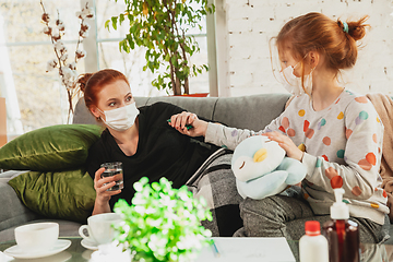 Image showing Mother and daughter in protective masks and gloves isolated at home with coronavirus symptoms, stop epidemic