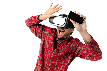 Image showing Man emotional playing, using virtual reality headset isolated on white studio background