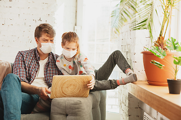 Image showing Father and daughter in protective masks and gloves isolated at home with coronavirus symptoms, stop epidemic