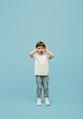 Image showing Happy caucasian little boy isolated on blue studio background. Looks happy, cheerful, sincere. Copyspace. Childhood, education, emotions concept