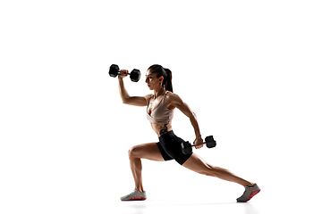 Image showing Caucasian professional female athlete training isolated on white studio background. Muscular, sportive woman.