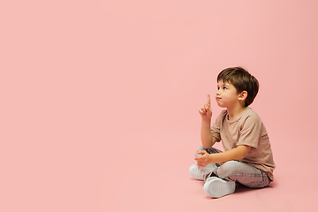 Image showing Happy caucasian little boy isolated on pink studio background. Looks happy, cheerful, sincere. Copyspace. Childhood, education, emotions concept