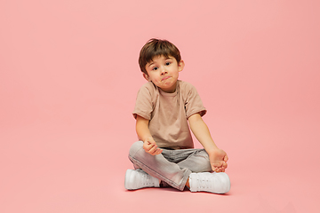 Image showing Happy caucasian little boy isolated on pink studio background. Looks happy, cheerful, sincere. Copyspace. Childhood, education, emotions concept