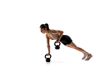 Image showing Caucasian professional female athlete training isolated on white studio background. Muscular, sportive woman.