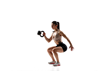 Image showing Caucasian professional female athlete training isolated on white studio background. Muscular, sportive woman.