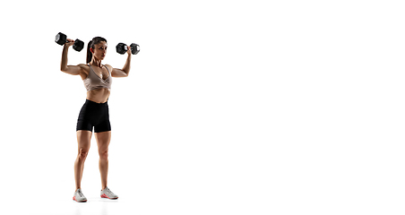 Image showing Caucasian professional female athlete training isolated on white studio background. Muscular, sportive woman.