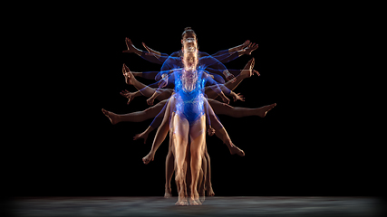 Image showing Young flexible girl on black studio background in strobe and neon light. Young female model practicing artistic gymnastics.