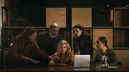 Image showing Young colleagues working together in a office styled like classical artworks. Look busy, attented, cheerful, successful. Concept of business, office, finance.