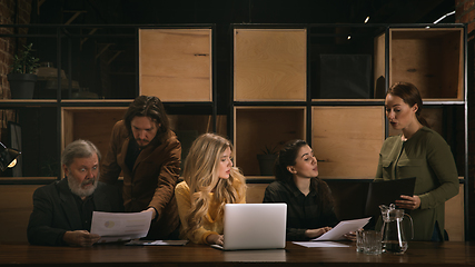 Image showing Young colleagues working together in a office styled like classical artworks. Look busy, attented, cheerful, successful. Concept of business, office, finance.