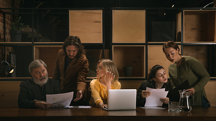 Image showing Young colleagues working together in a office styled like classical artworks. Look busy, attented, cheerful, successful. Concept of business, office, finance.