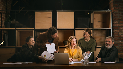 Image showing Young colleagues working together in a office styled like classical artworks. Look busy, attented, cheerful, successful. Concept of business, office, finance.