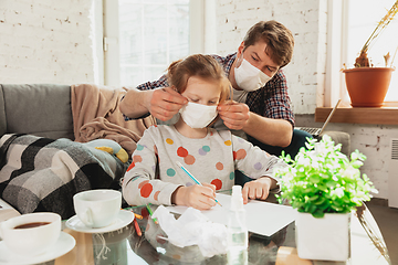 Image showing Father and daughter in protective masks and gloves isolated at home with coronavirus symptoms, stop epidemic