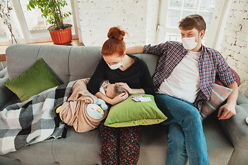 Image showing Caucasian family in protective masks and gloves isolated at home with coronavirus symptoms, treatment