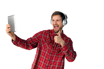 Image showing Man using tablet and headphones isolated on white studio background