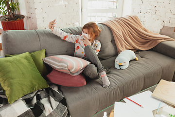 Image showing Little girl in protective mask isolated at home with coronavirus symptoms, stop epidemic