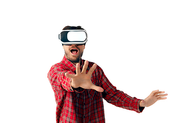 Image showing Man emotional playing, using virtual reality headset isolated on white studio background