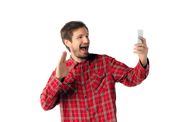 Image showing Emotional caucasian man using smartphone isolated on white studio background