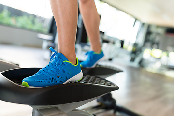 Image showing Sport woman working out on elliptical trainer in gym