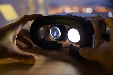 Image showing Male hand holding VR device at night