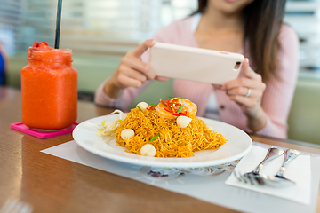 Image showing Woman taking photo on fried noodles with cellphone