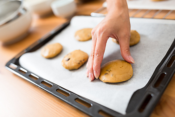 Image showing Woman putting paste on metal tray