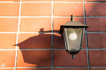 Image showing Street lamp over red brick wall