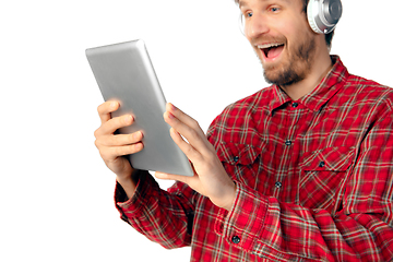 Image showing Man using tablet and headphones isolated on white studio background