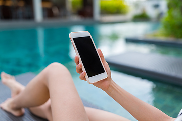 Image showing Woman using cellphone and lying besides swimming pool