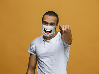 Image showing Portrait of young african-american man with emotion on his protective face mask