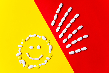 Image showing Colored pills, tablets and capsules on a red and yellow background - history of treatment, prevention of pandemic