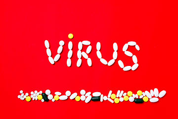 Image showing Colored pills, tablets and capsules on a red background - history of treatment, prevention of pandemic