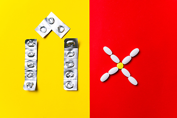 Image showing Colored pills, tablets and capsules on a red and yellow background - history of treatment, prevention of pandemic