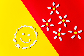 Image showing Colored pills, tablets and capsules on a red and yellow background - history of treatment, prevention of pandemic