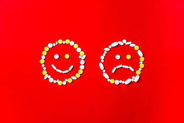 Image showing Colored pills, tablets and capsules on a red background - history of treatment, prevention of pandemic