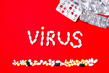 Image showing Colored pills, tablets and capsules on a red background - history of treatment, prevention of pandemic