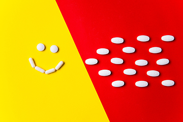 Image showing Colored pills, tablets and capsules on a red and yellow background - history of treatment, prevention of pandemic