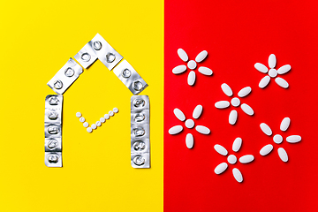 Image showing Colored pills, tablets and capsules on a red and yellow background - history of treatment, prevention of pandemic