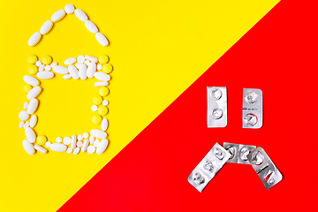 Image showing Colored pills, tablets and capsules on a red and yellow background - history of treatment, prevention of pandemic