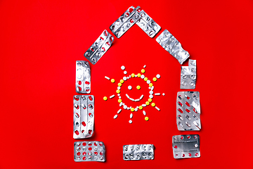 Image showing Colored pills, tablets and capsules on a red background - history of treatment, prevention of pandemic