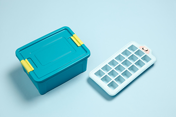 Image showing Closed lunch box, ice form. Monochrome stylish composition in blue color. Top view, flat lay.