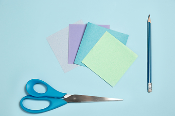 Image showing Sticker papers, scissors, pen. Monochrome stylish composition in blue color. Top view, flat lay.